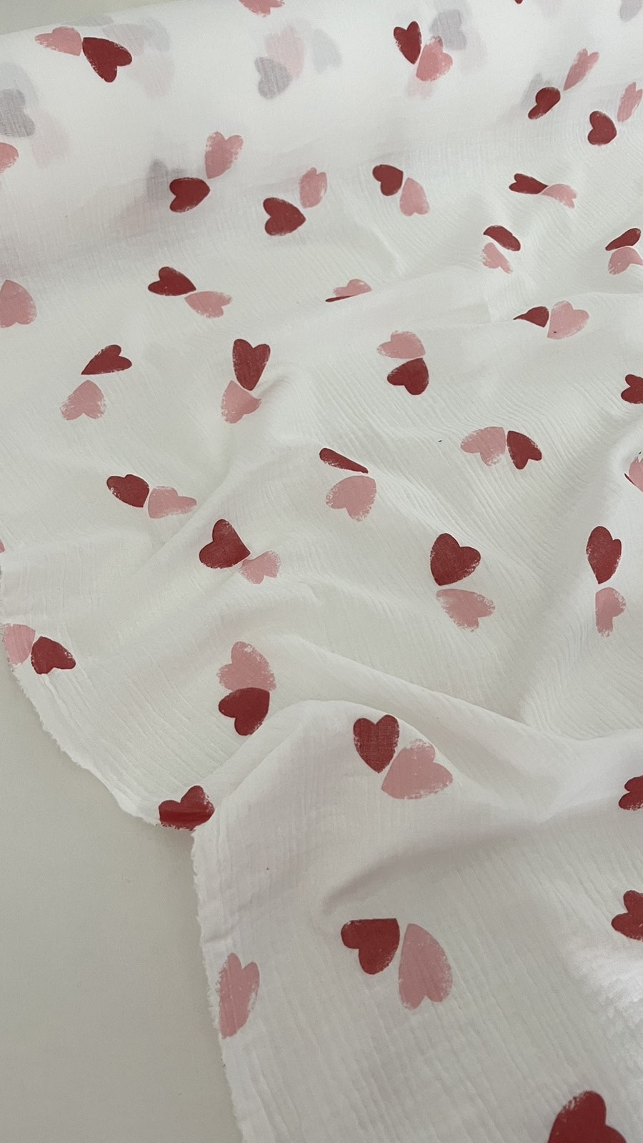 Муслін двошаровий рожеві та червоні серця на молочному 135 см арт. 3795