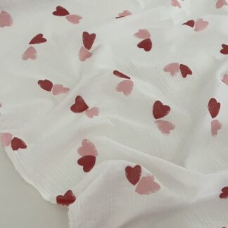 Муслін двошаровий рожеві та червоні серця на молочному 135 см арт. 3795